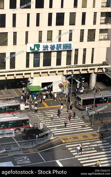View of the southern exit of Shibuya Station, famous for its moai statue, with buses and taxis stopped at the bus terminal