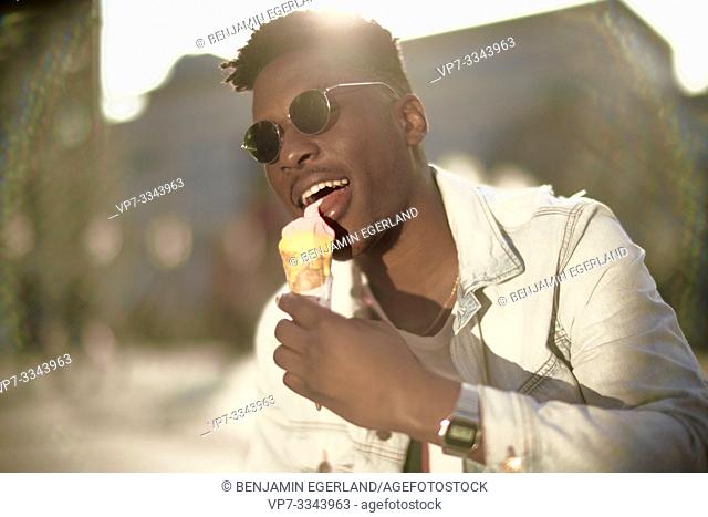 young African man licking ice cream, in Munich, Germany