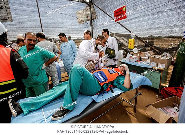 An injured Palestinian medic receives treatment at a medical tent, during clashes with Israeli security forces along the Israel-Gaza border