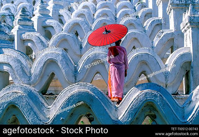 Myanmar, Mingun, Mandalay Division, Buddhist nun standing on white arches of Hsinbyume Pagoda