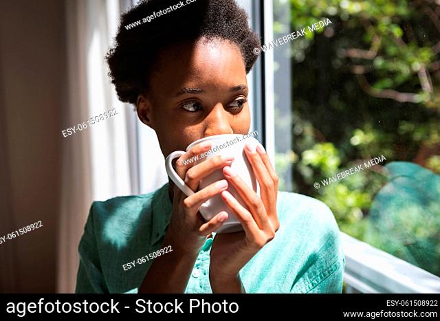 Woman drinking coffee while looking out of the window