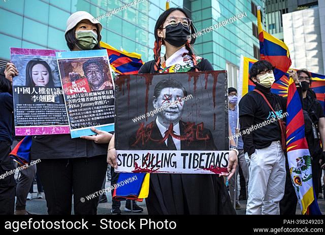 A woman holds a placard with an image of People's Republic of China President Xi Jin Ping and the inscription "" Stop killing Tibetans