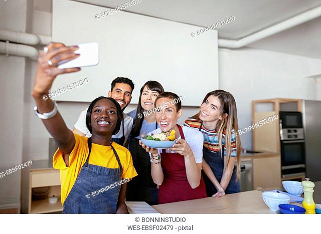 Friends and instructor in a cooking workshop taking a selfie