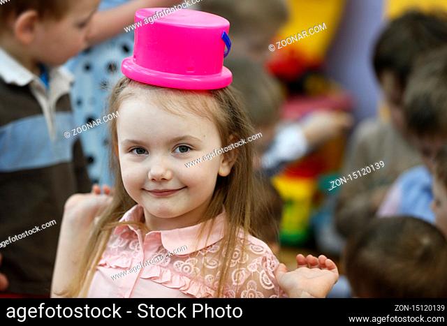 Girl with a bucket on her head.The child jokes