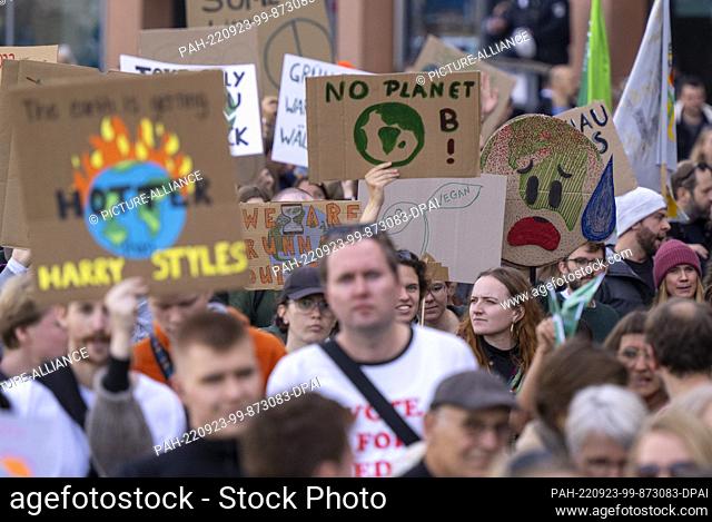 23 September 2022, Berlin: Numerous people march with posters and signs with demands to politics across the Marschall Bridge past the Reichstag building during...