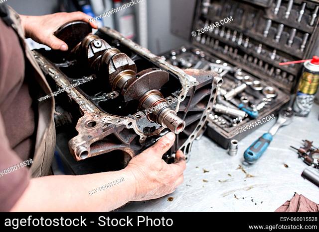 Engine crankshaft, valve cover, pistons. mechanic repairman at automobile car engine maintenance repair work