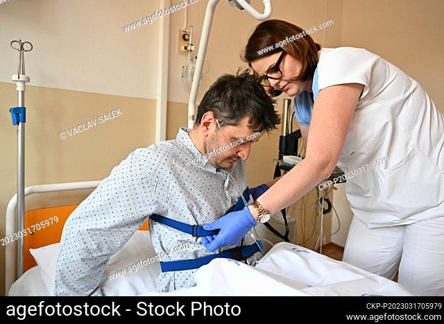 Head nurse Dana Dvorackova, right, helps a patient during an examination in the sleep laboratory of the University Hospital in Brno, March 17, 2023
