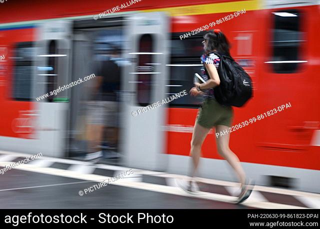 30 June 2022, Hessen, Frankfurt/Main: A woman walks to an S-Bahn train in the main station (shot with longer shutter speed)