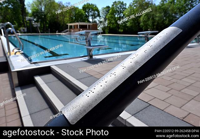 12 May 2022, Thuringia, Sömmerda: Markings in Braille are attached to the handrail at the Sömmerda municipal pool. With the start of this year's outdoor pool...
