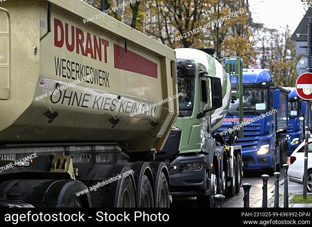 25 October 2023, North Rhine-Westphalia, Duesseldorf: Concrete mixers and gravel trucks, including one from the Durant-Weserkieswerk Höxter with the slogan ""No...