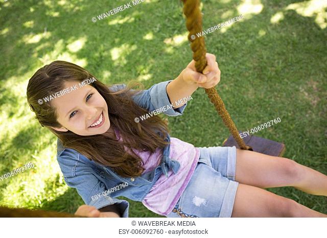 Cute little young girl sitting on swing