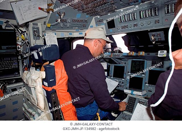 Astronaut Lee Archambault, STS-117 pilot, occupies the commander's station on the flight deck of Space Shuttle Atlantis during rendezvous and docking operations...
