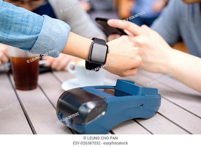 Woman pay by smart watch on pos machine