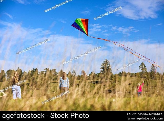03 October 2023, Baden-Württemberg, Hayingen: Two women and a girl fly a kite in the Swabian Alb. Photo: Thomas Warnack/dpa