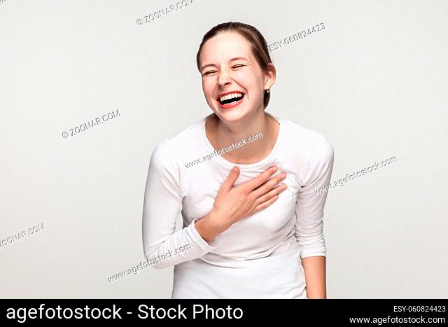 Funny concept. Expressing young adult freackles woman toothy smiling. Studio shot, isolated on gray background
