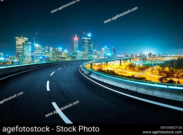 Blue neon light design highway overpass with modern city background . Night scene