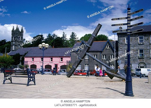 Town square. Large black ship anchor. Pink painted houses/ church