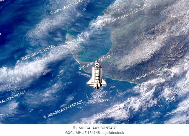 The Space Shuttle Endeavour is backdropped over the Tasman Sea and Golden Bay of New Zealand's South Island as it approaches the International Space Station...