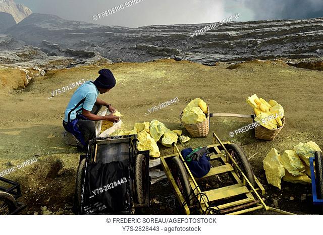Sulfur miner carrying load of solid sulfur at the Kawah Ijen volcano in Java, Indonesia