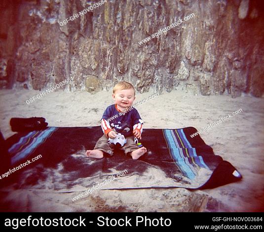 Happy Baby Boy sitting on Beach Blanket