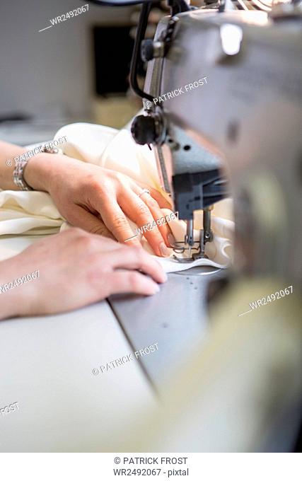 Woman working at sewing machine in bridal shop