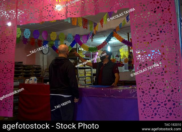 MEXICO CITY, MEXICO - OCTOBER 21: A worker from the ""Taller de Yuriria"" wears a protective mask, while using a template to cutting a traditional Mexican paper...