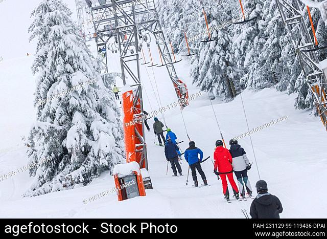 29 November 2023, Baden-Württemberg, Seebach: Winter sports enthusiasts are pulled up a ski slope by a T-bar lift. The lift at Seibelseckle in the Ortenau...