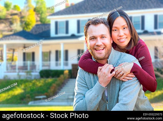 Mixed Race Caucasian and Chinese Couple In Front Yard of Beautiful Custom House
