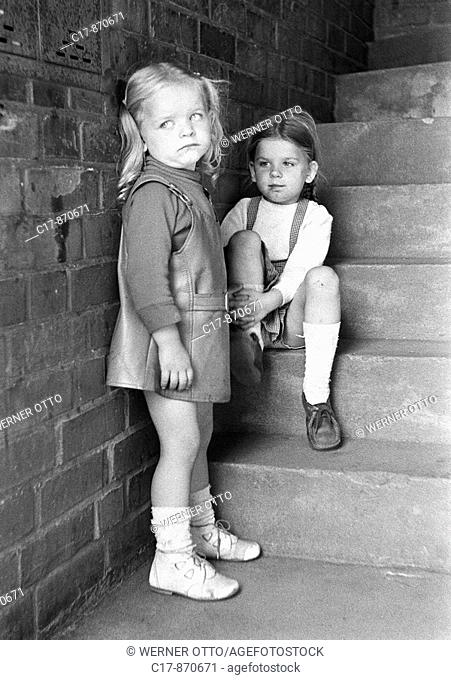 Seventies, black and white photo, people, children, two little girls in a hallway, brick wall, stone stairs, aged 3 to 5 years