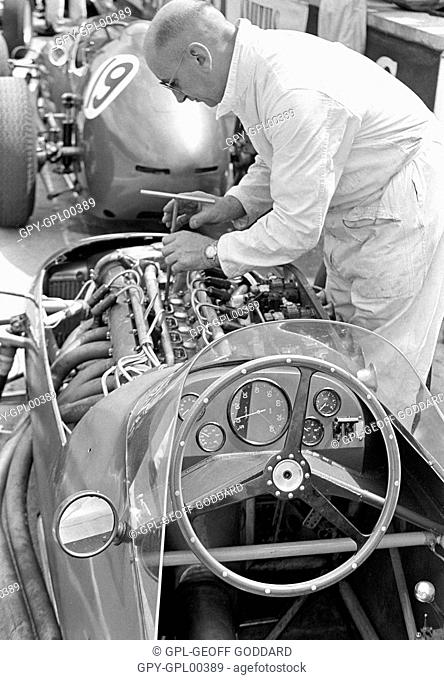 A mechanic working on an Aston Martin DBR4 engine at Silverstone, England 1960