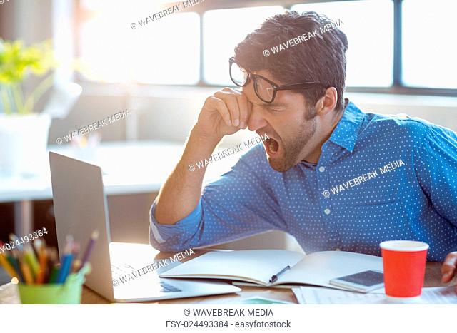 Male business executive yawning