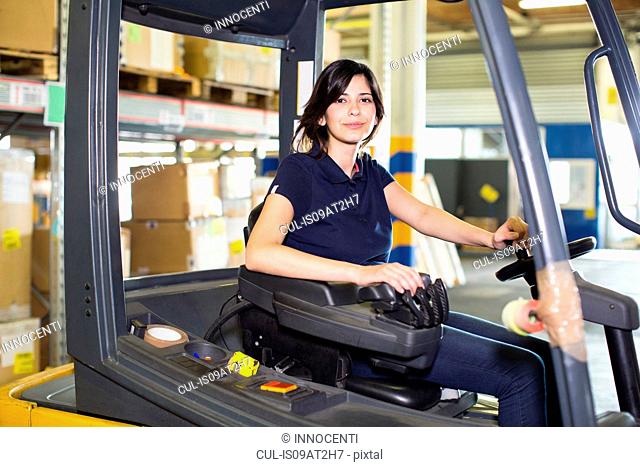 Portrait of female forklift truck driver working in distribution warehouse