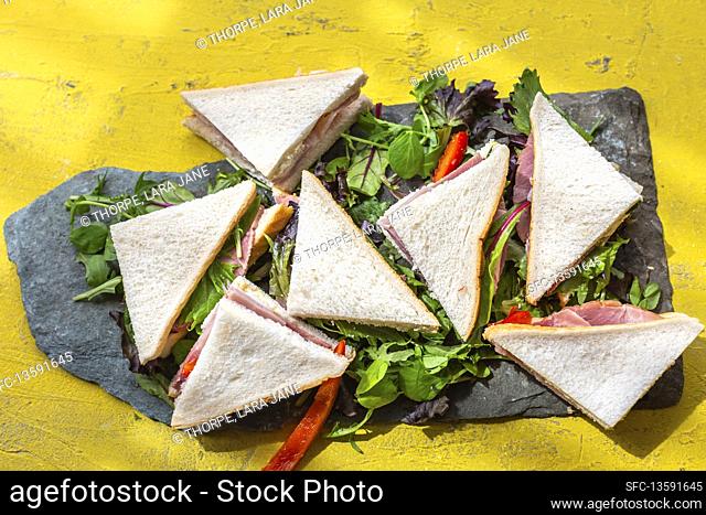 Sandwich corners with ham on lettuce leaves