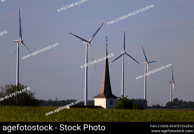 02 June 2021, Bavaria, Biebelried: Wind turbines stand behind the church of Kaltensondheim. (to dpa-KORR: ""Turn to dependency - Bavaria will be less and less...