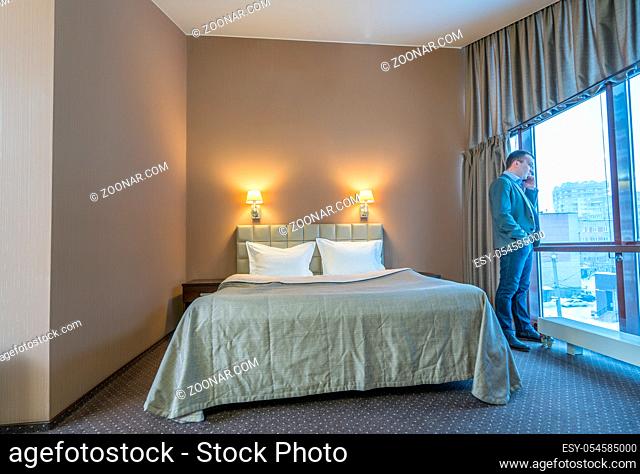 Businessman talking on cell phone in luxury hotel room