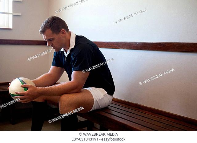 Serious rugby player sitting on bench