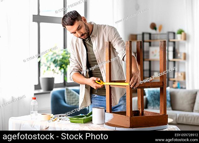 man with ruler measuring table for renovation