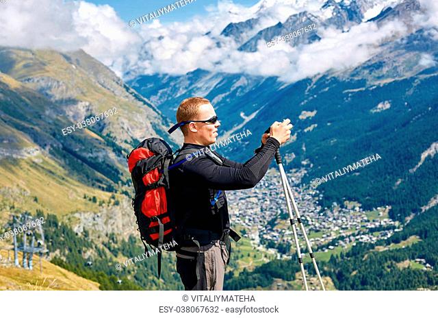 hiker at the top of a pass with camera enjoy sunny day in Alps. Switzerland, Trek near Matterhorn mount