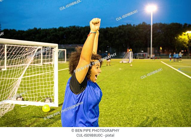 Female football player jubilant, Hackney, East London, UK