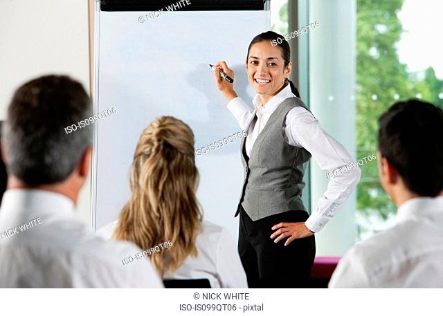 Woman using whiteboard in business meeting