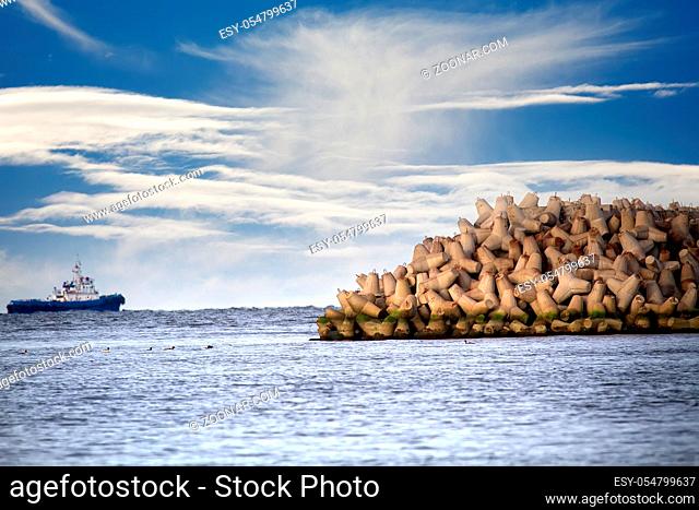 The seawall around the sea port facilities is made of concrete tetrapods (traveling-wave protection), rubble-mound breakwater. Duty marine tug