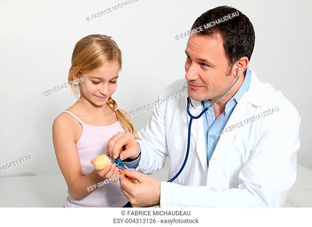 Doctor and little girl listening to doll's breathing