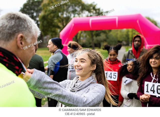 Daughter placing medal around neck of father at charity run