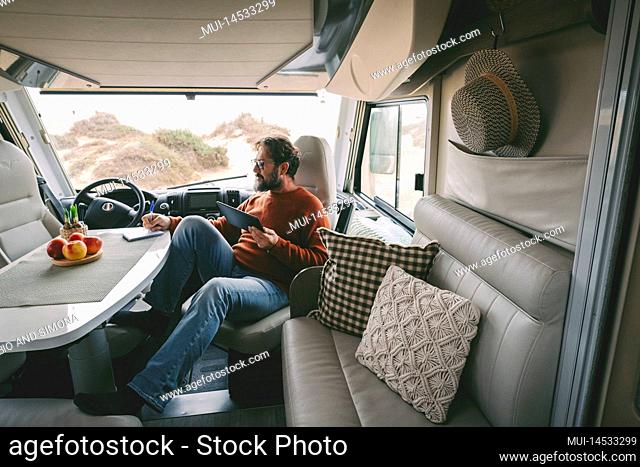 Inside view of traveler woman enjoying sunset time on the camper van rv door. Travel and wanderlust lifestyle modern trendy people concept