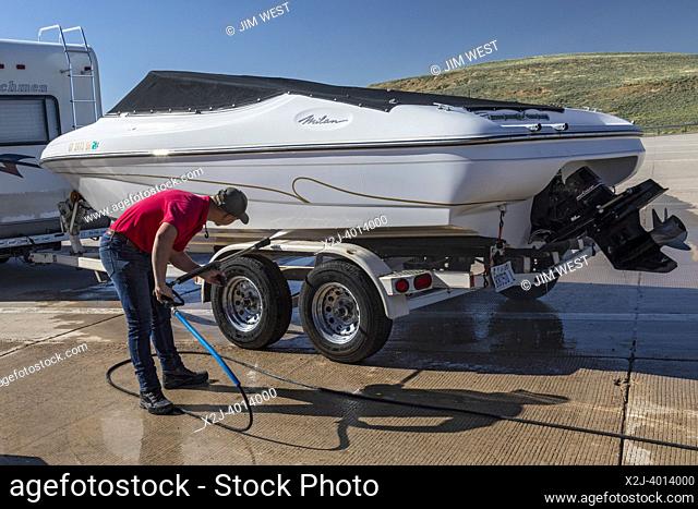 Evanston, Wyoming - An employee of the Wyoming Game & Fish Department inspects and decontaminates watercraft at a mandatory inspection station along the Utah...