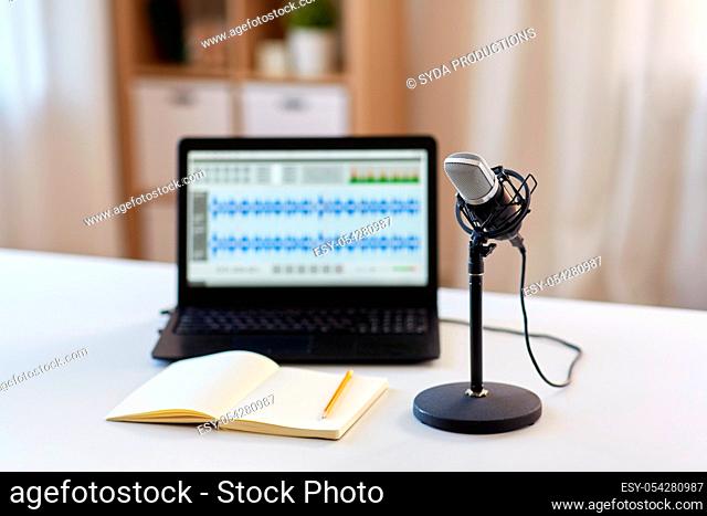 microphone, laptop and notebook on table