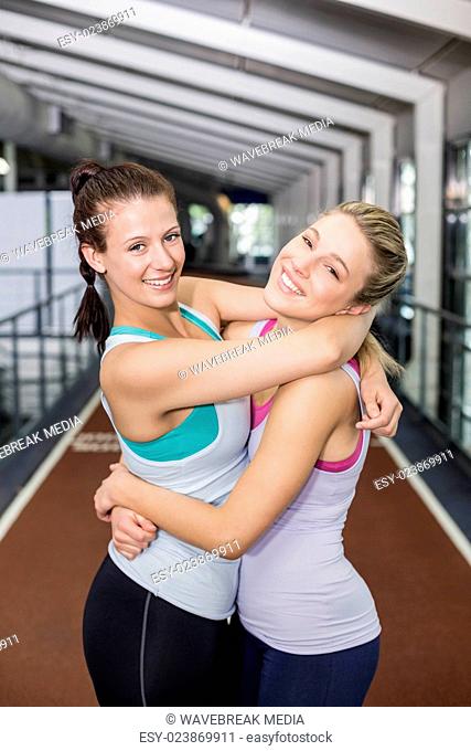 Smiling athletic friends hugging