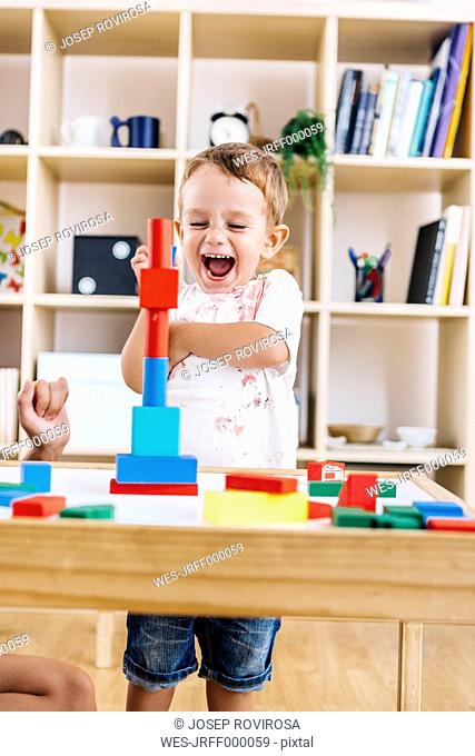 Portrait of excited little boy playing with building bricks
