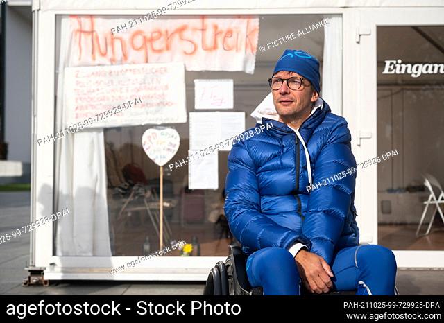 25 October 2021, Berlin: Steffen Helbing, chairman of the Brandenburg State Association of the Deaf, sits outside his tent in front of the Federal Chancellery