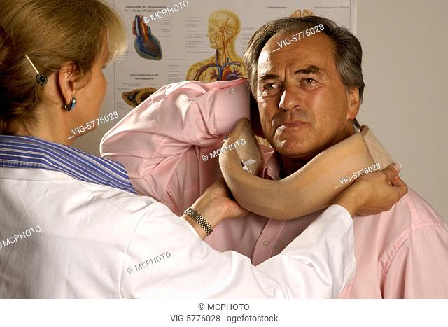 Eine Aerztin legt einem aelteren Mann eine Halskrause an, MR, 2007| A lady doctor put a neckfrill on the neck from a old man - Hamburg, Hamburg, Germany